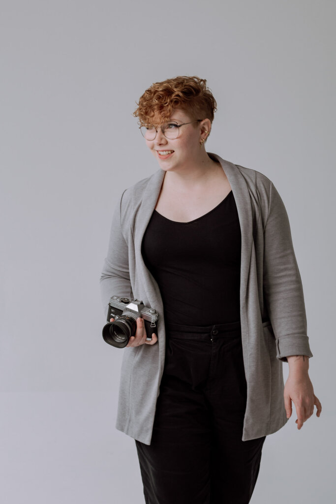 Businessfotogarf-Bremen-Frau-mit-Kamera-lächelt zur Seite