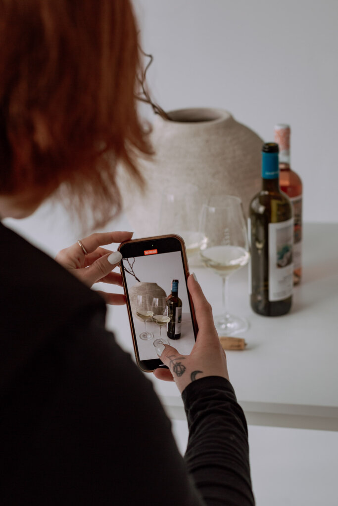 Businessfotograf-Bremen-Eine-Frau-filmt-Weinflaschen mit ihrem Handy