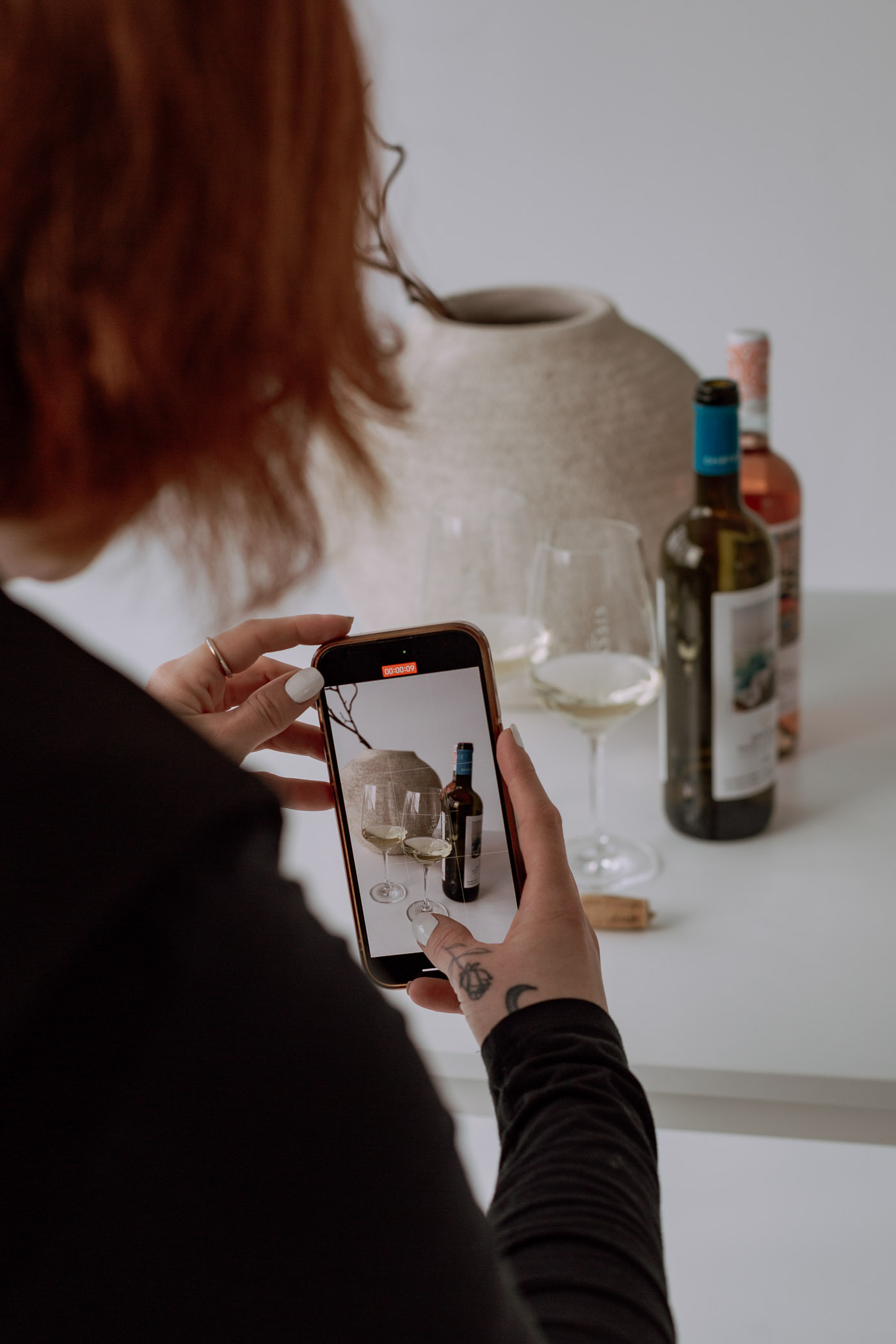 Businessfotograf-Bremen-Eine-Frau-filmt-Weinflaschen mit ihrem Handy