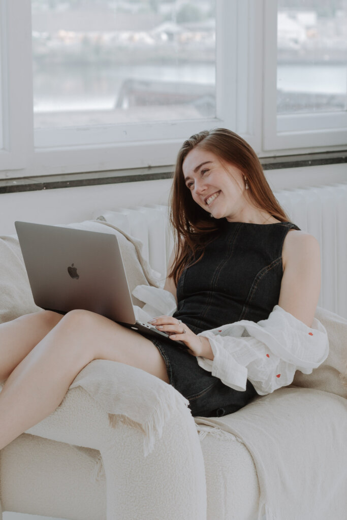 Businessfotograf-Bremen-Eine-Frau-sitzt-am-Laptop-und-lacht