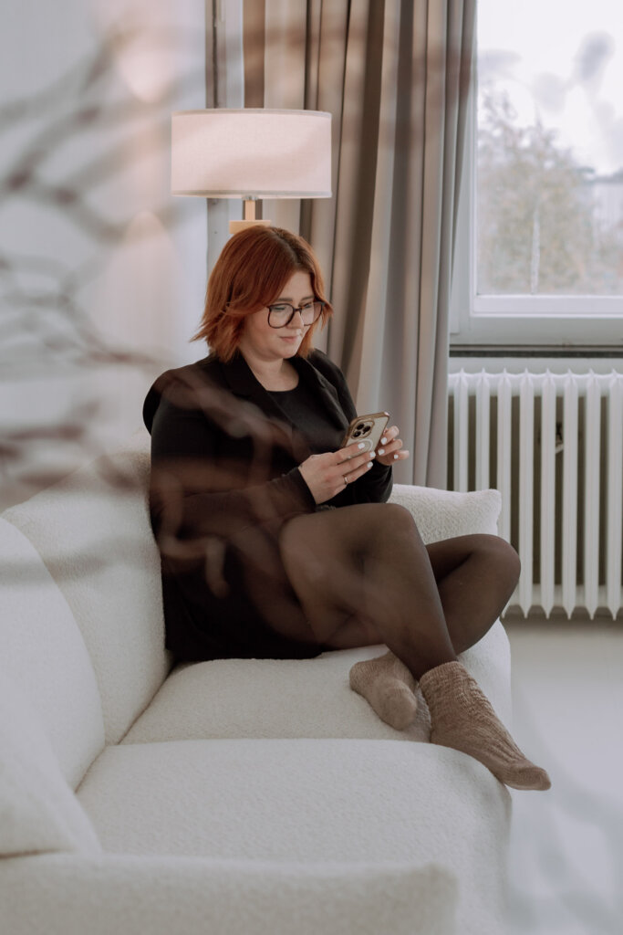 Businessfotograf-Bremen-Eine-Frau-sitzt-mit-ihrem-Handy-auf-dem-Sofa
